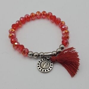 red iridescent crystal stretch bracelet with tassel and saint charm